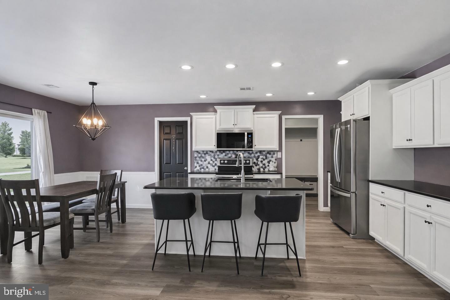10 Coriander Lane Manchester, PA 17345 - Photo 7 of 25 a kitchen with stainless steel appliances kitchen island granite countertop a dining table chairs refrigerator and sink