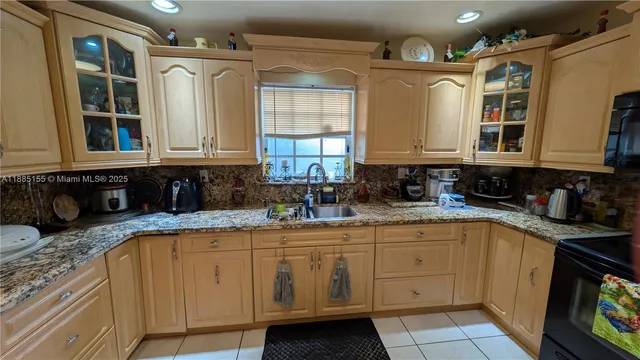 a kitchen with stainless steel appliances granite countertop a sink a stove and cabinets