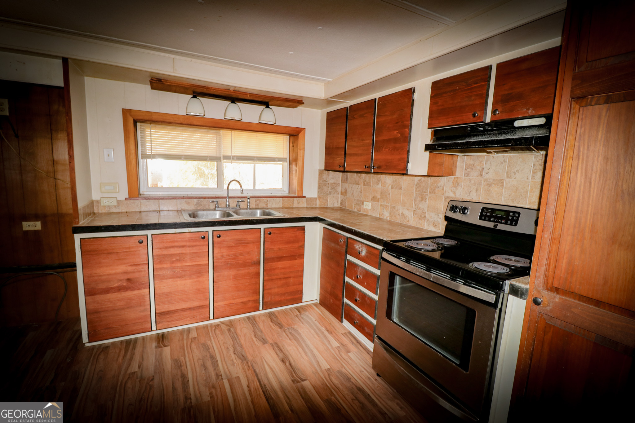 2447 Williamson Road Williamson, GA 30292 - Photo 21 of 95 a kitchen with granite countertop wooden floors and stainless steel appliances