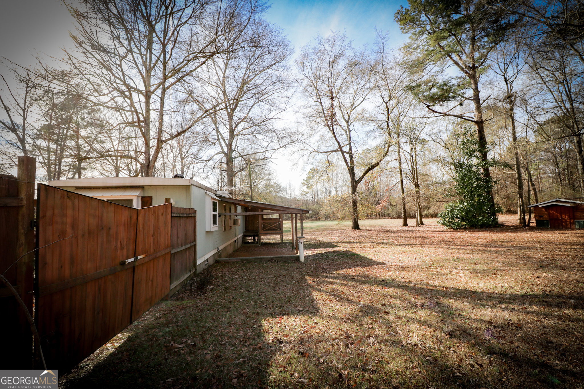 2447 Williamson Road Williamson, GA 30292 - Photo 39 of 95 a view of a backyard with wooden fence and large trees