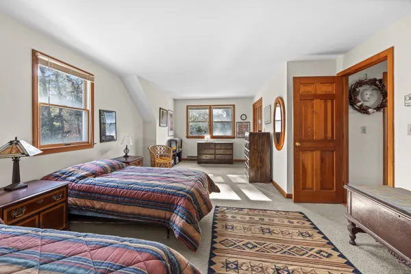 a bedroom with a bed and a dresser next to a window