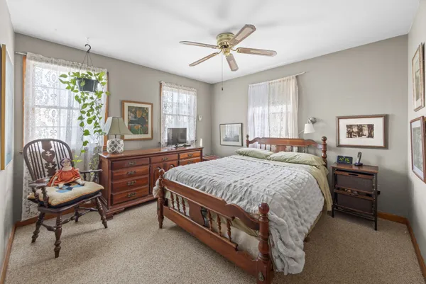 a bedroom with a bed chair and a window