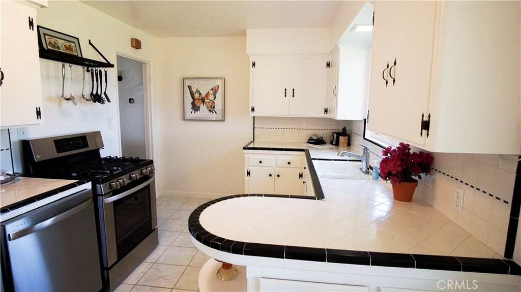 701 Williams Avenue Madera, CA 93637 - Photo 9 of 20 a kitchen with stainless steel appliances a white stove top oven a sink and dishwasher