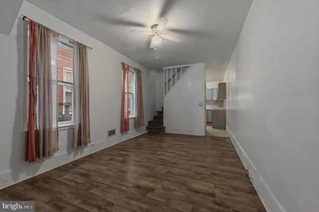 a view of empty room with wooden floor