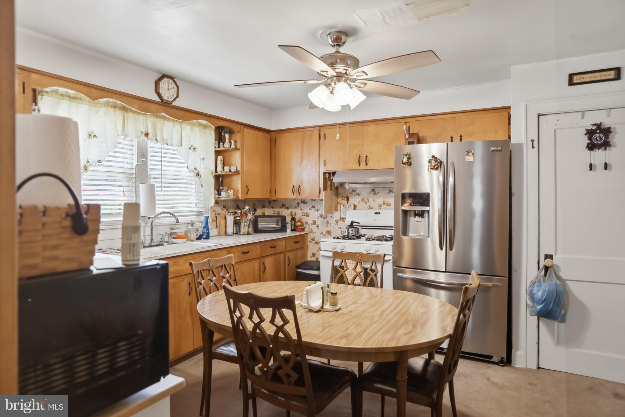 378 Spruce Street Thomas, WV 26292 - Photo 12 of 30 a kitchen with stainless steel appliances granite countertop a dining table chairs refrigerator and sink