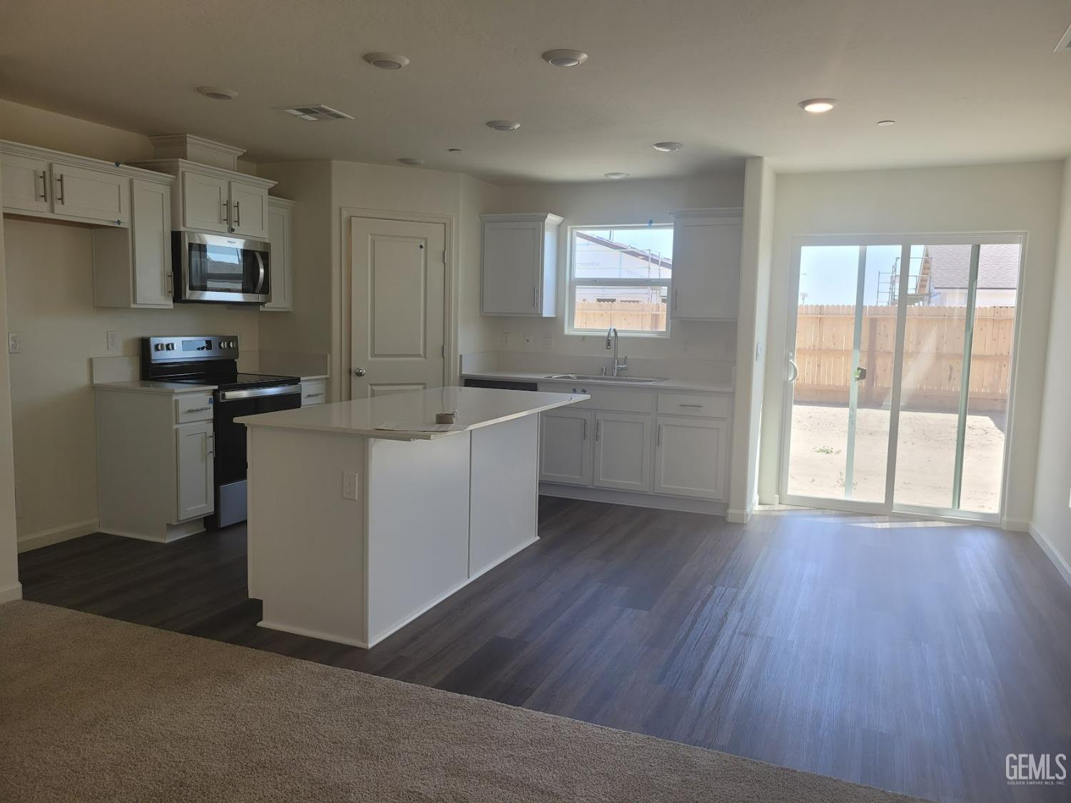 Undisclosed Address Bakersfield, CA 93307 - Photo 6 of 24 a view of a kitchen with a sink wooden floor and windows