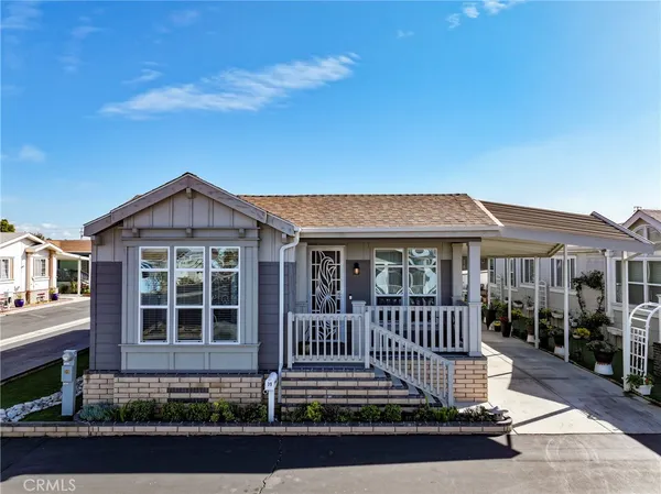 a view of a house with a small yard and wooden fence