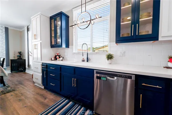 a dining room with stainless steel appliances a table chairs and a kitchen view