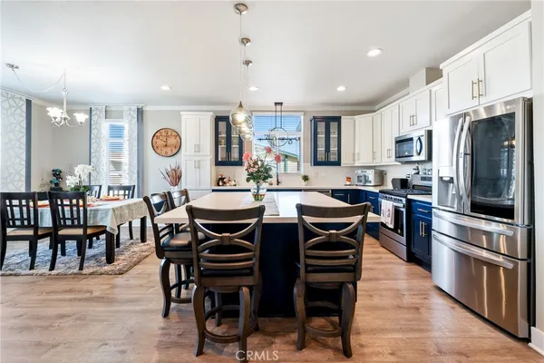 a living room with furniture kitchen view and a large window