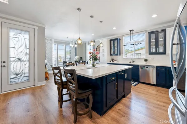 a kitchen with a dining table chairs and stainless steel appliances