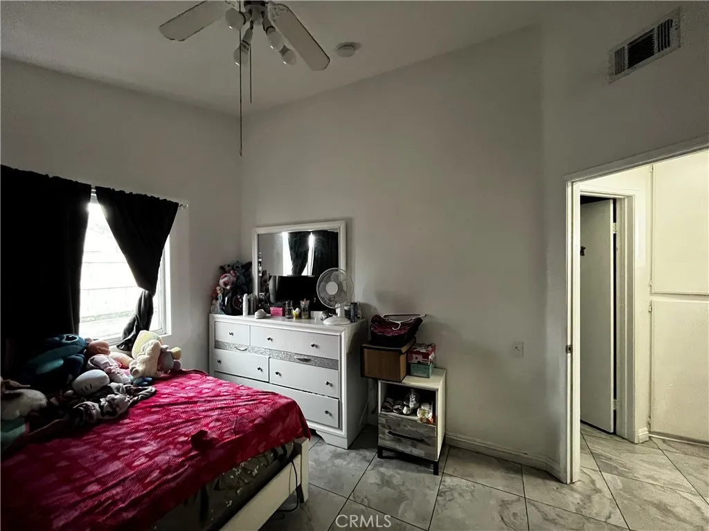 1208 North Fillmore Avenue Rialto, CA 92376 - Photo 10 of 19 a bedroom with a bed and a flat tv screen on dresser