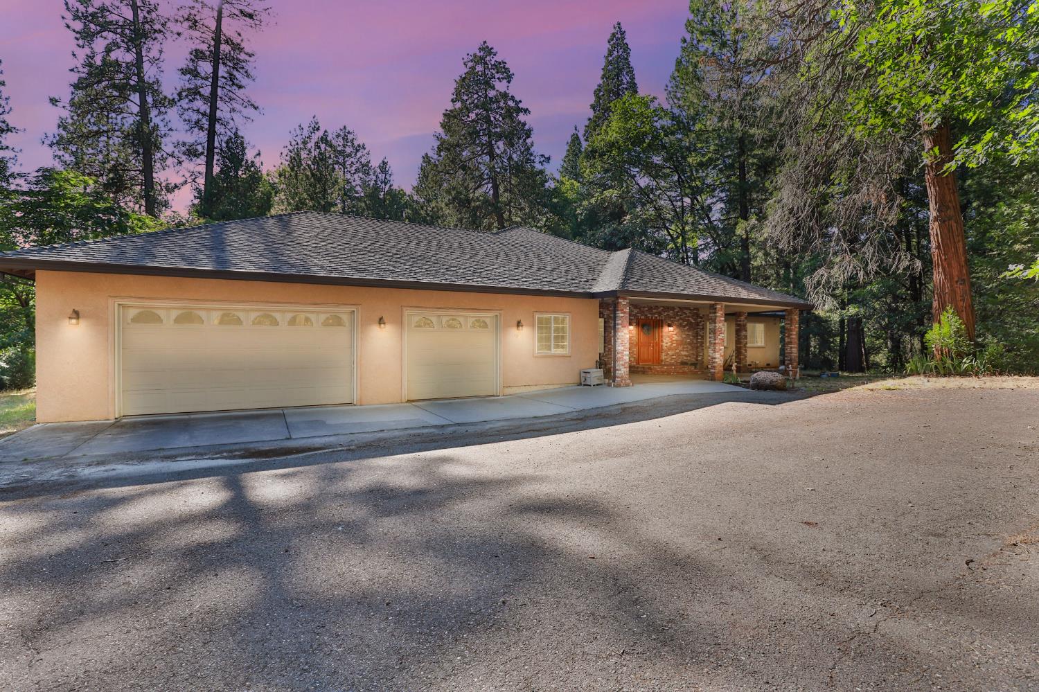 a view of house with yard and trees in the background