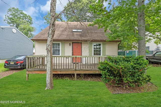 a view of a house with a backyard and deck