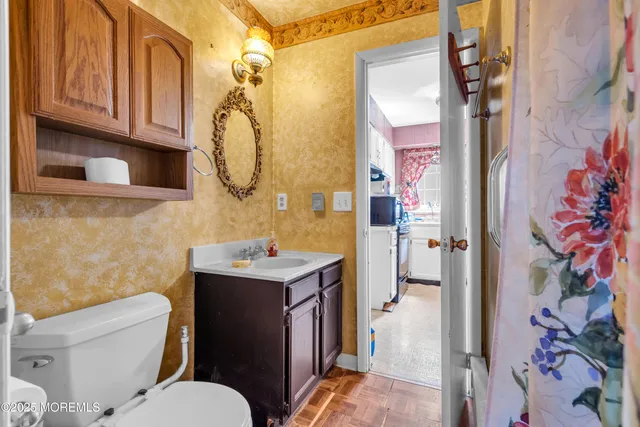 a bathroom with a granite countertop toilet sink and mirror