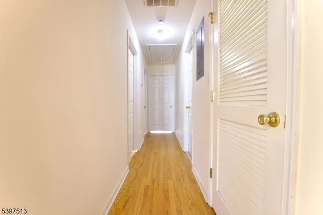 a view of an empty room with wooden floor