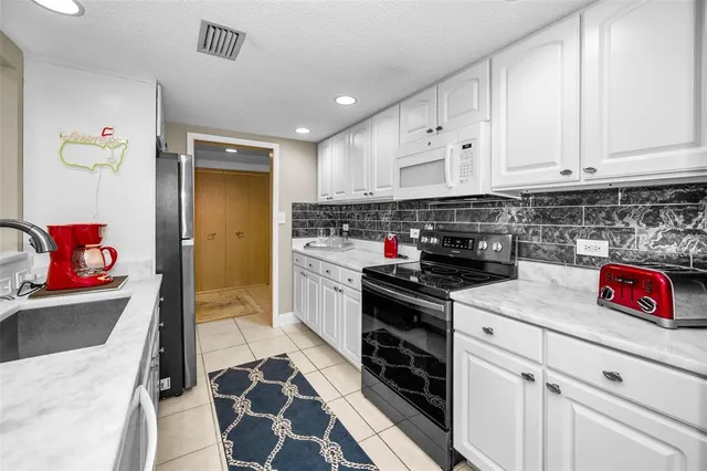 a view of a big house with a big yard and large trees