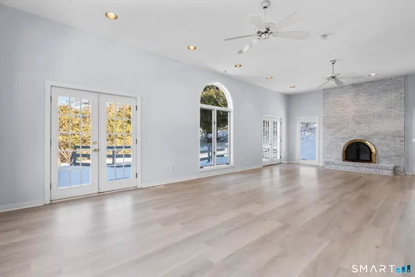 an empty room with windows and fireplace