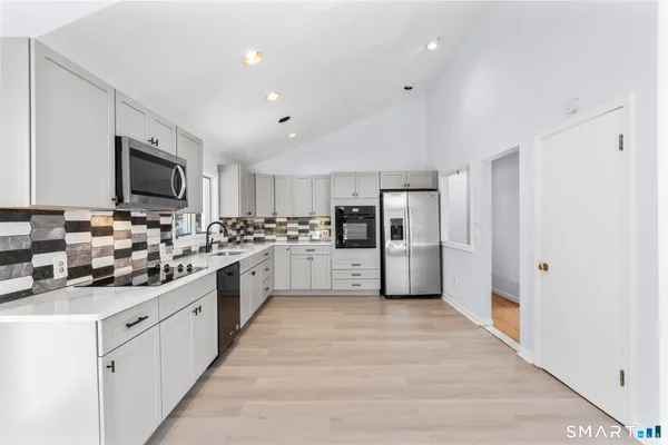 a large kitchen with cabinets and stainless steel appliances