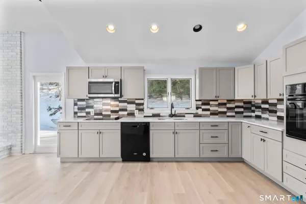 a kitchen with stainless steel appliances granite countertop a stove a sink dishwasher and a refrigerator