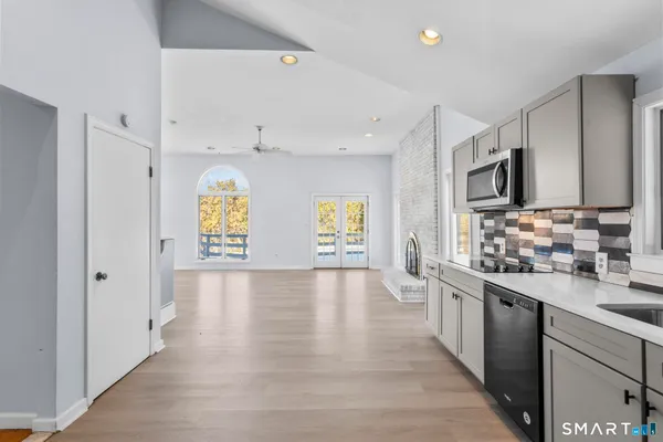 a large kitchen with stainless steel appliances granite countertop a lot of counter space and a window
