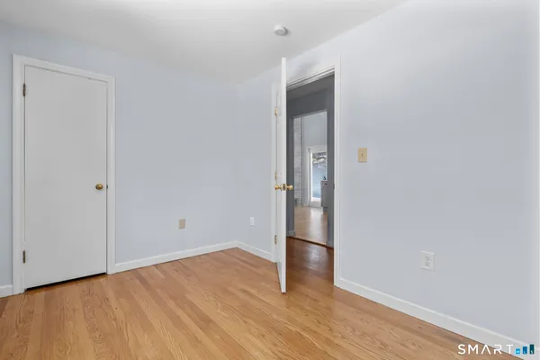 a view of empty room with wooden floor