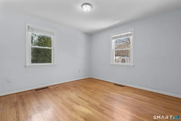 a view of empty room with wooden floor