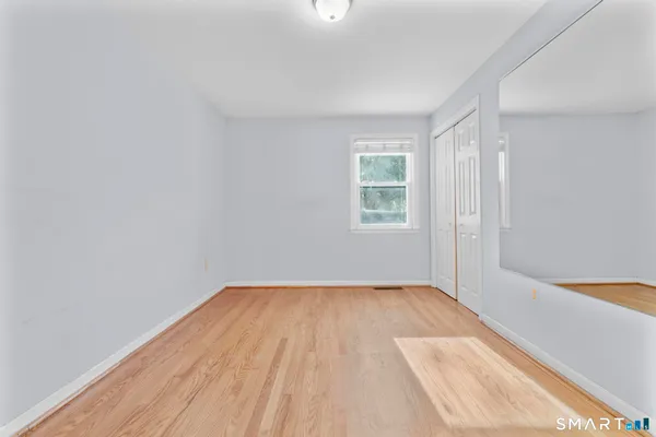 a view of a room with a wooden floor and a window