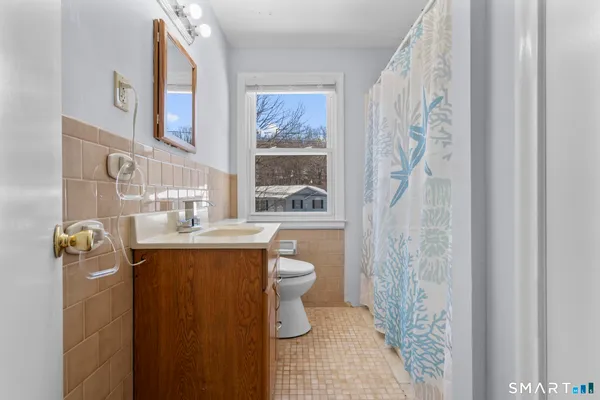 a bathroom with a sink a toilet and shower curtain