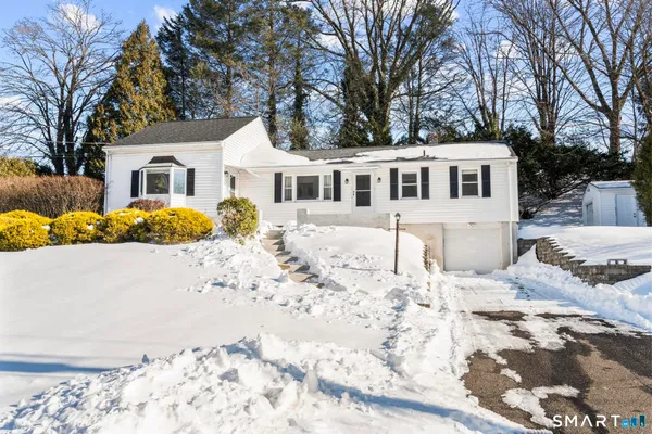 a front view of a house with a yard covered in snow