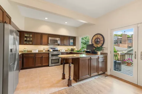 a kitchen with stainless steel appliances granite countertop a stove a sink and a refrigerator