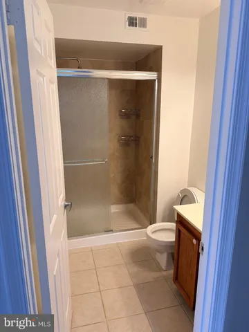 a bathroom with a granite countertop shower and a toilet