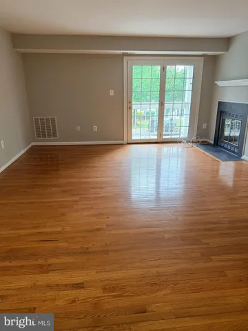 a view of empty room with window and wooden floor