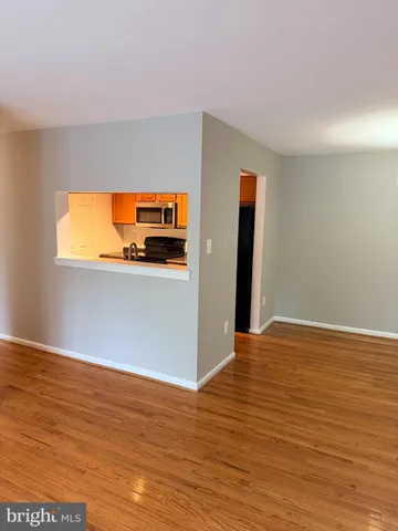 a view of a room with wooden floor and a window