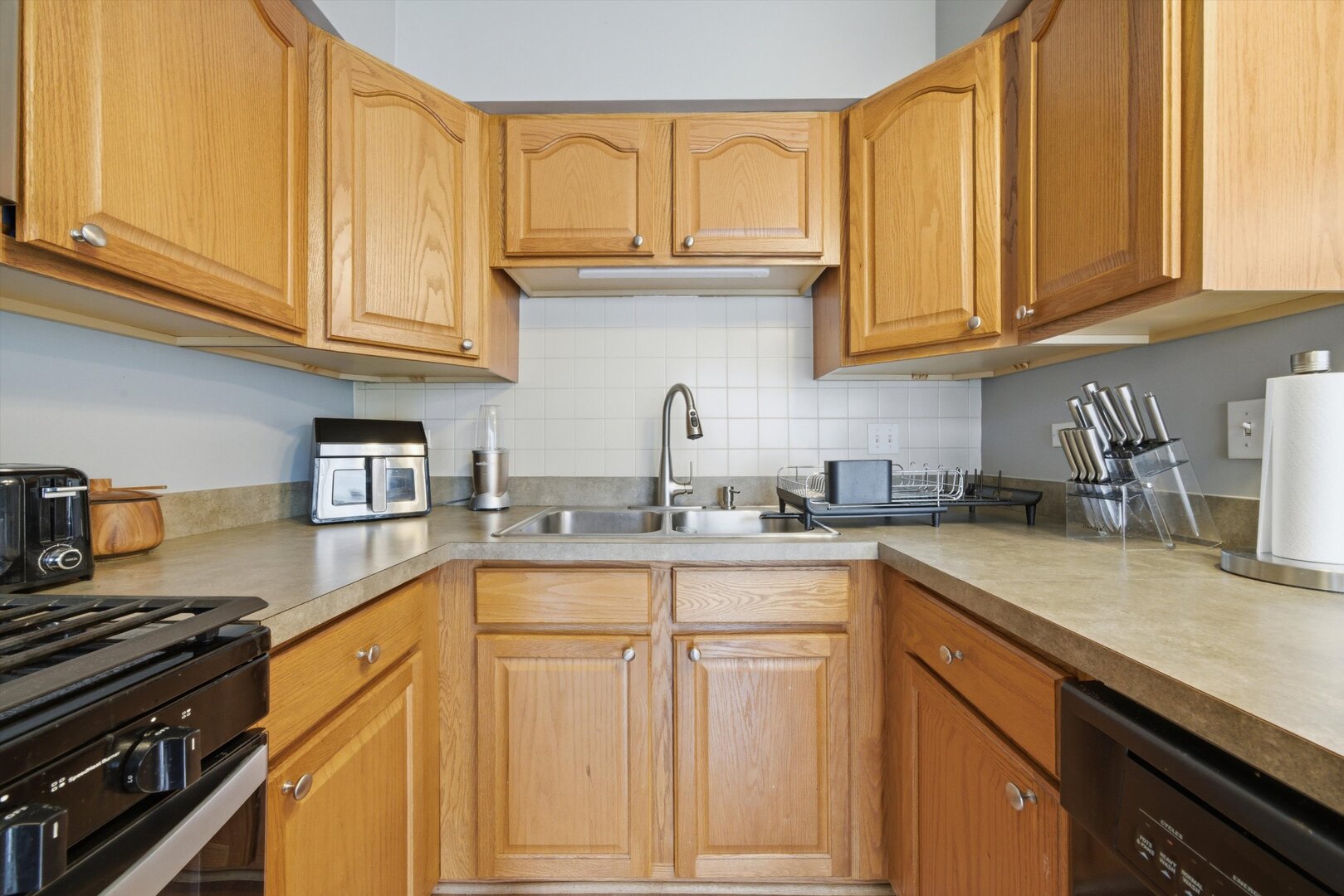 8820 Plainfield Road Brookfield, IL 60513 - Photo 16 of 49 a kitchen with stainless steel appliances granite countertop a sink dishwasher stove and cabinets with wooden floor