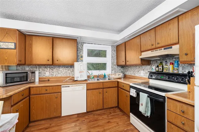 a dining room with stainless steel appliances a table and chairs with kitchen view