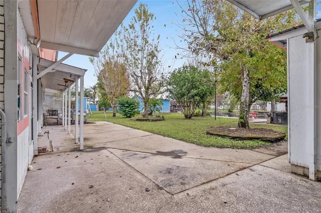 a view of a house with a yard and large tree
