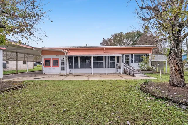 a front view of a house with a yard and tree