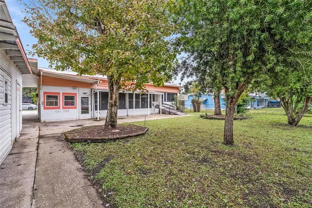 a view of a house with a patio and a yard
