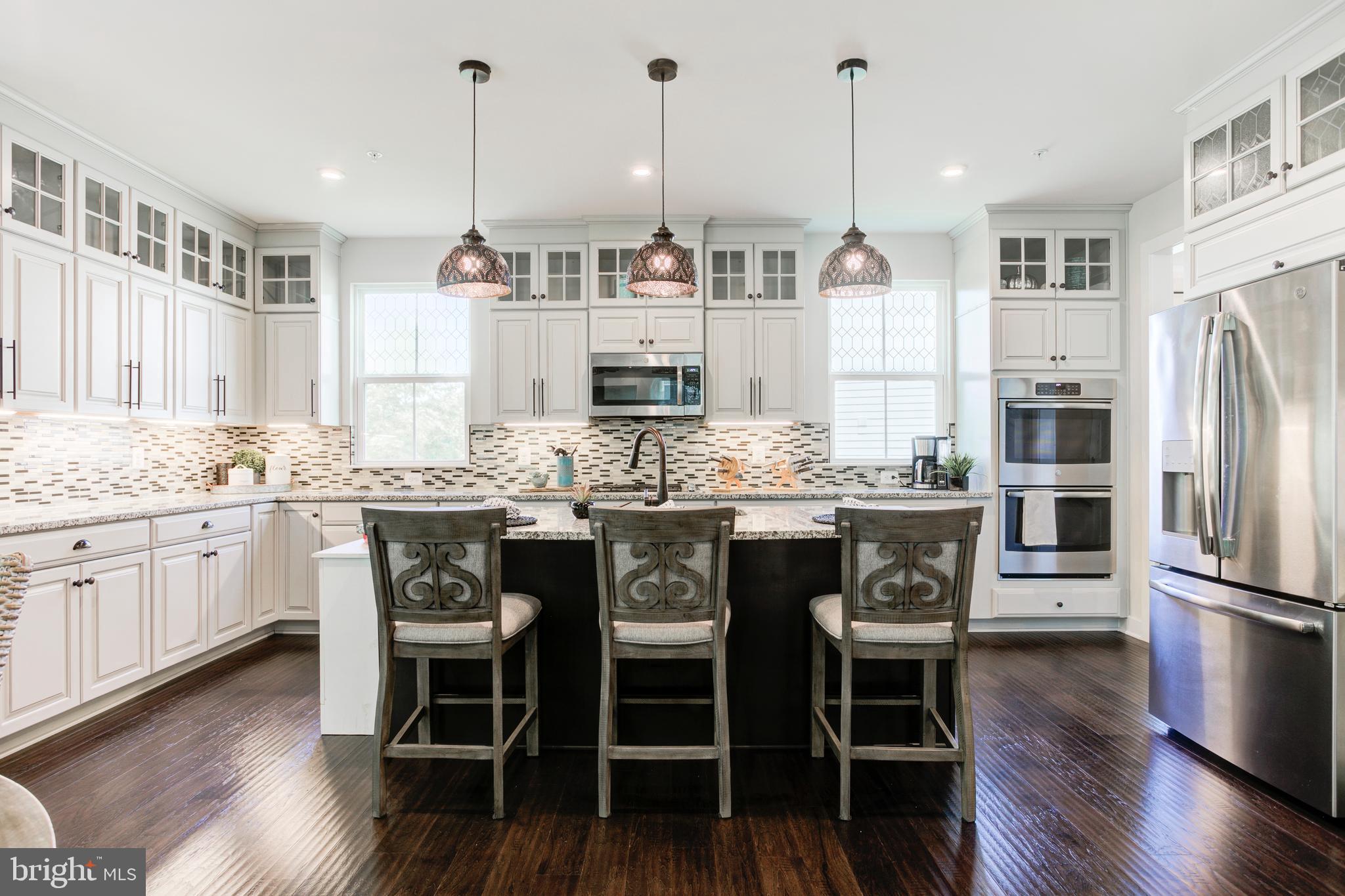 2346 Sweet Pepperbrush Loop Dumfries, VA 22026 - Photo 22 of 84 a kitchen with stainless steel appliances granite countertop a kitchen island hardwood floor and a sink