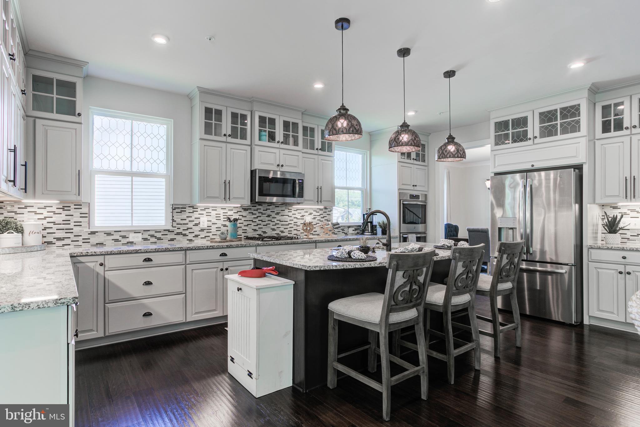 2346 Sweet Pepperbrush Loop Dumfries, VA 22026 - Photo 25 of 84 a kitchen with stainless steel appliances kitchen island granite countertop a kitchen island hardwood floor and a sink