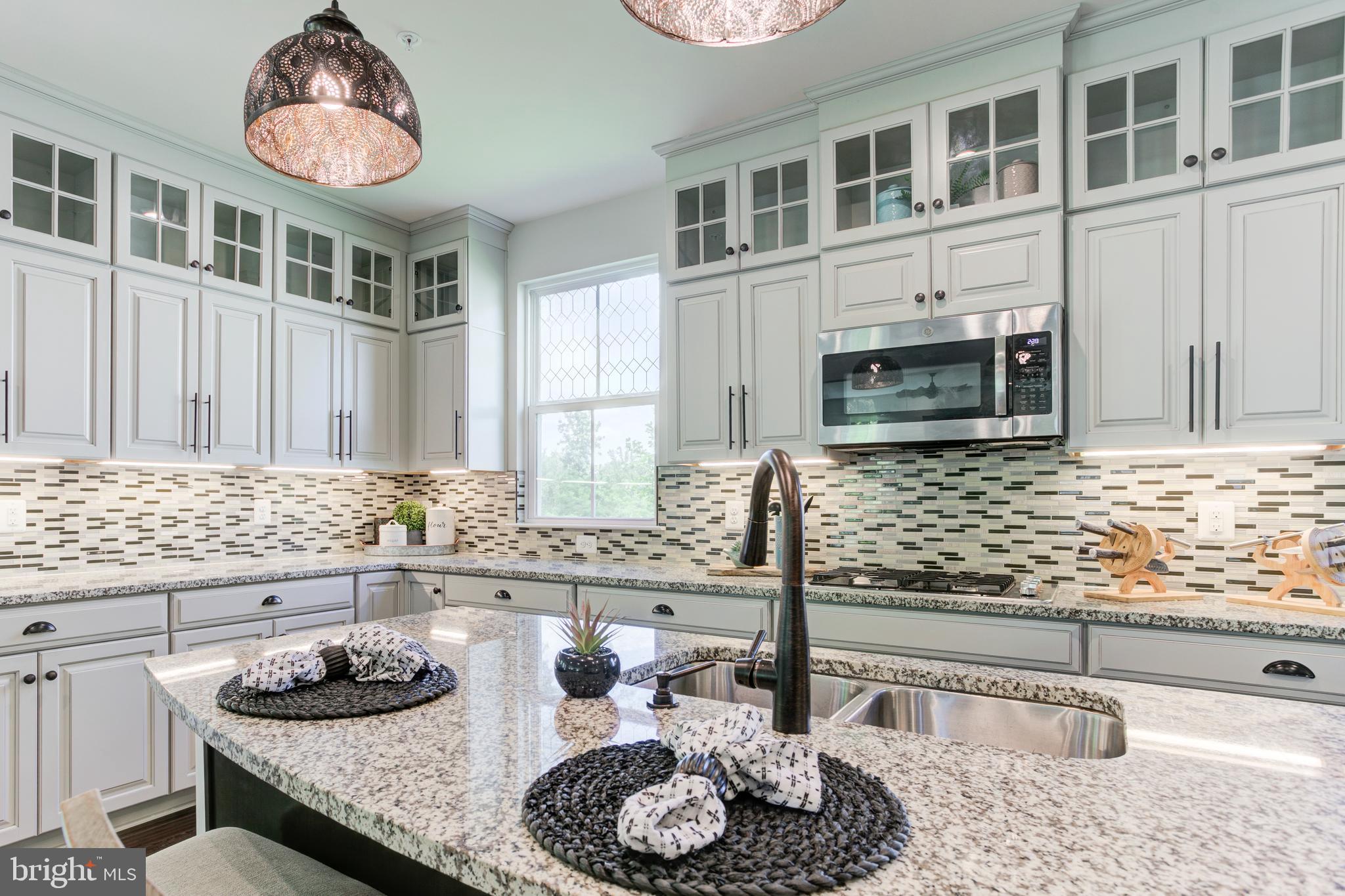 2346 Sweet Pepperbrush Loop Dumfries, VA 22026 - Photo 27 of 84 a kitchen with granite countertop a sink and a stove