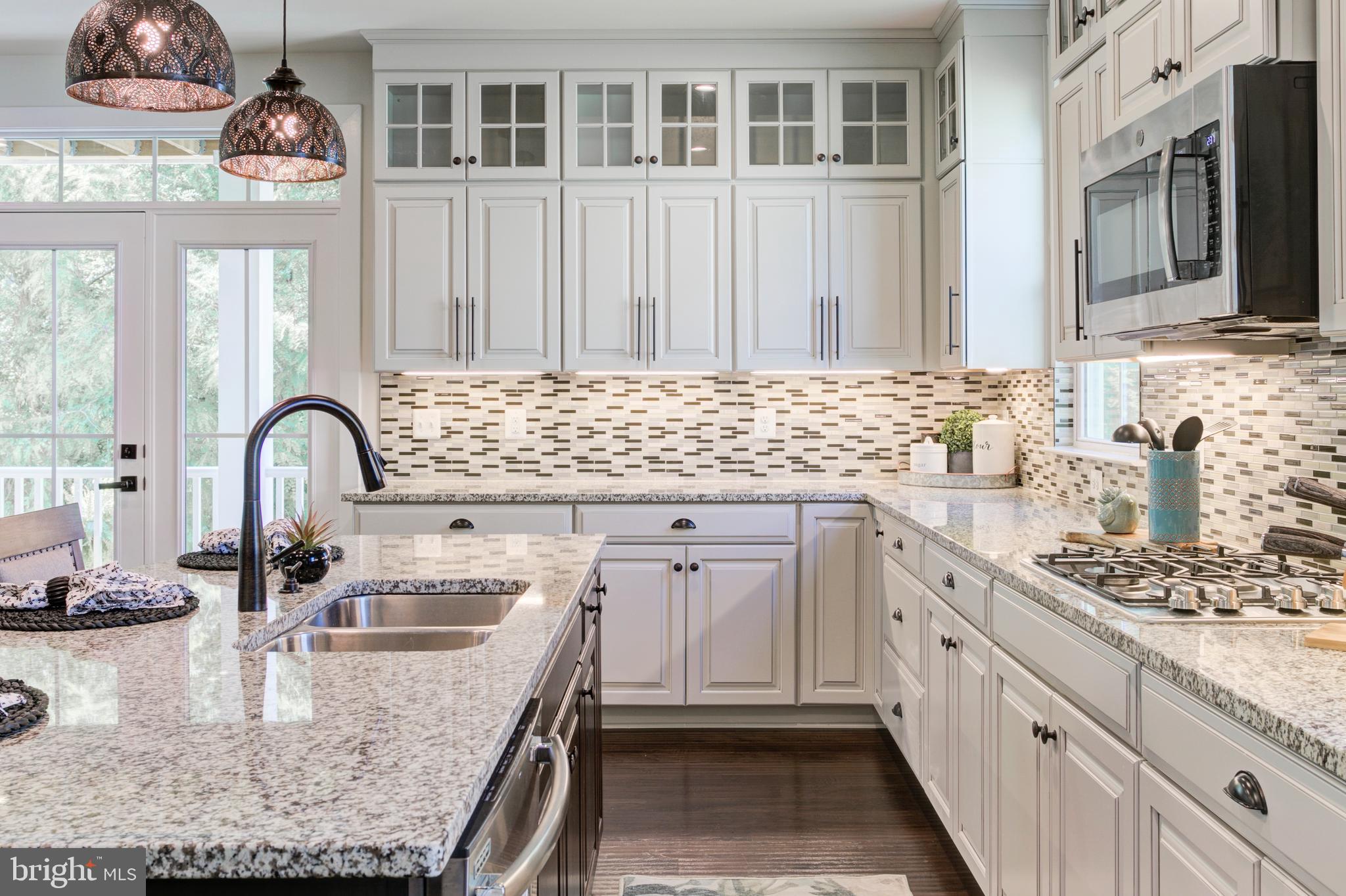 2346 Sweet Pepperbrush Loop Dumfries, VA 22026 - Photo 28 of 84 a kitchen with stainless steel appliances granite countertop a sink stove and cabinets
