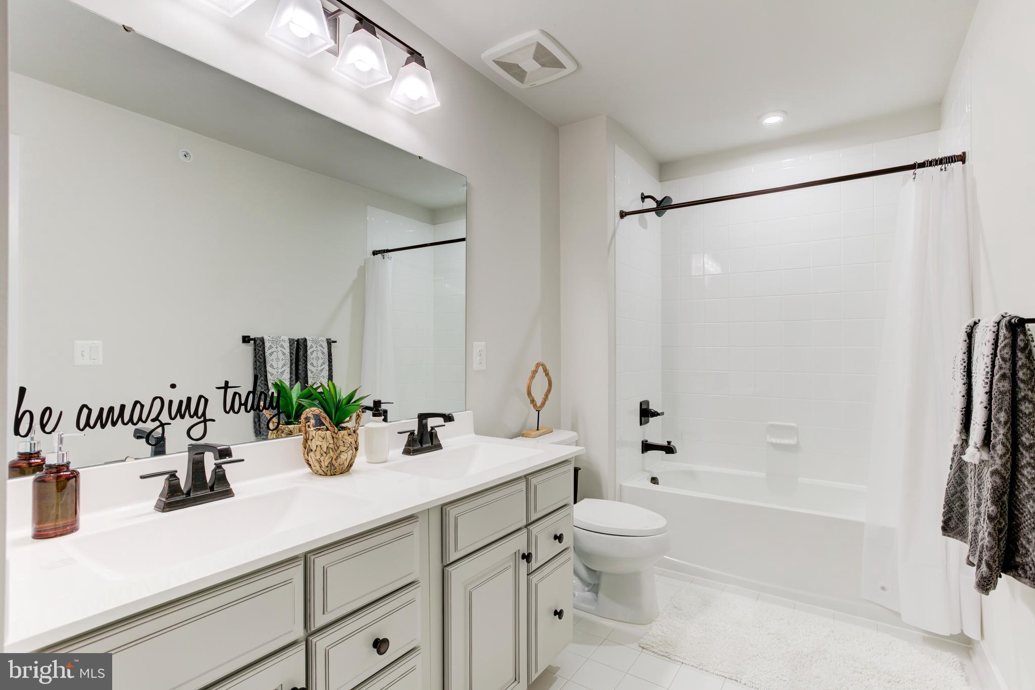 2346 Sweet Pepperbrush Loop Dumfries, VA 22026 - Photo 50 of 84 a bathroom with a double vanity sink toilet mirror and shower