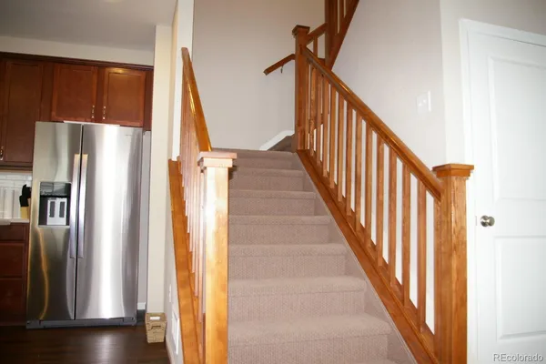 a view of a hallway with wooden floor and staircase