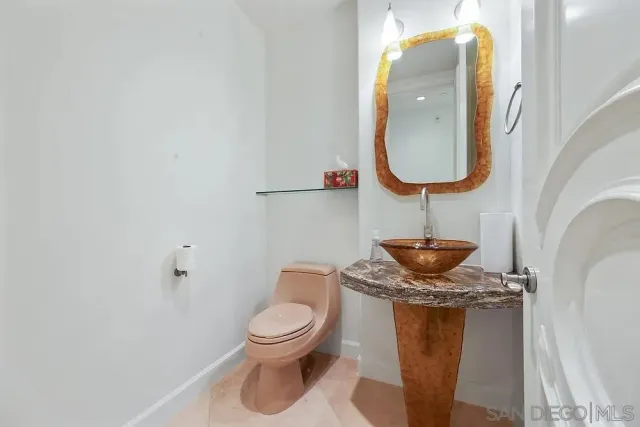 a bathroom with a toilet and a mirror