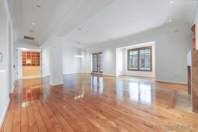 a view of empty room with wooden floor