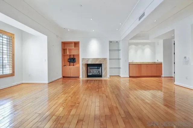 an empty room with wooden floor and fireplace