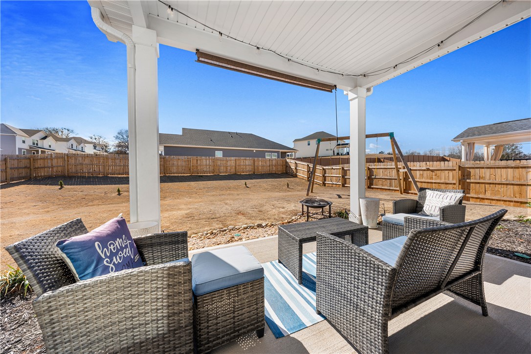 203 Maxwell Drive Easley, SC 29642 - Photo 31 of 34 Relax on the covered patio, perfect for enjoying the spacious yard and outdoor activities.