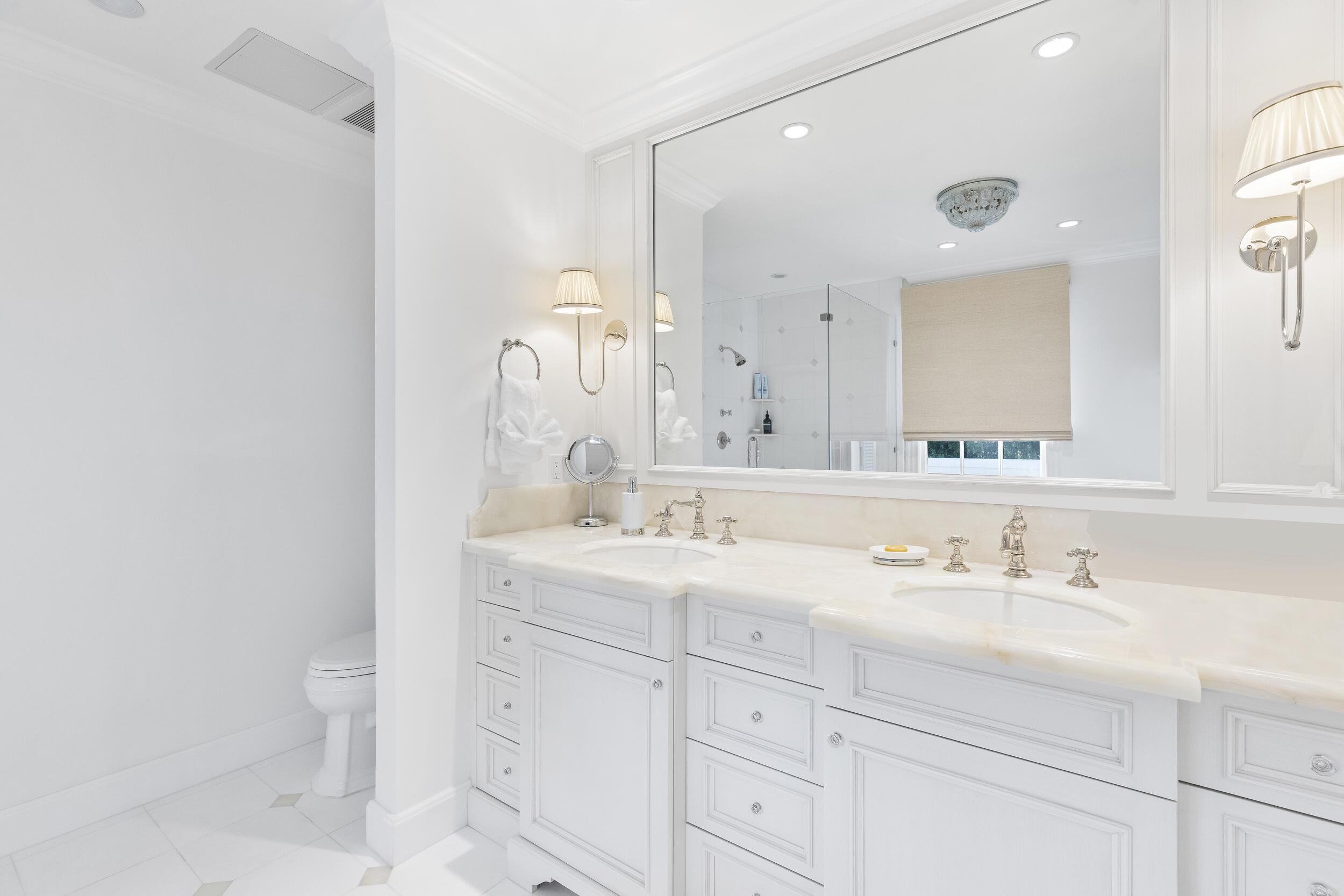 130 Cocoanut Row Palm Beach, FL 33480 - Photo 38 of 66 a bathroom with a sink a toilet and a mirror