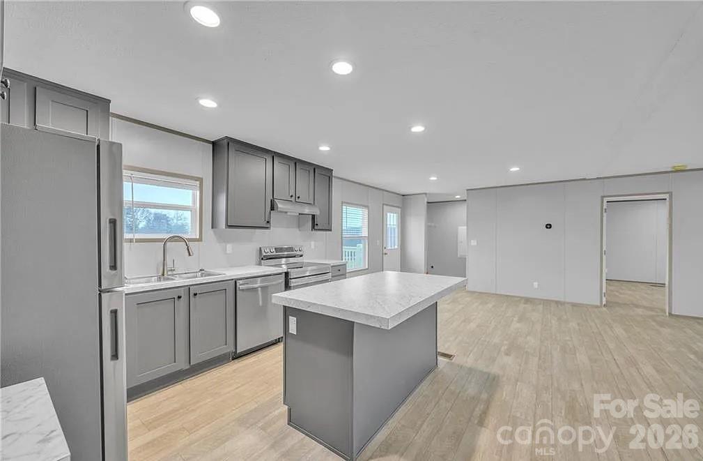 4935 Rhoney Road Connelly Springs, NC 28612 - Photo 13 of 36 a large kitchen with stainless steel appliances granite countertop a sink and a refrigerator